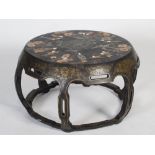 A late 19th/early 20th century Chinese lacquer and hardstone circular low table, the top centred