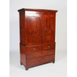 A George III mahogany linen press, the plain cornice above a pair of arched panelled doors,