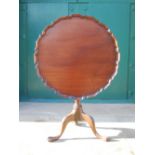 A George III mahogany snap top occasional table, the hinged circular top with scalloped edge, raised