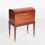 A George III mahogany dome top chest on stand, the hinged cover opening to an embroidered cloth