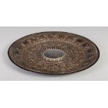 A late 19th/early 20th century Indian white metal circular dish/tray, the central circular roundel