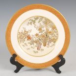 A Japanese Satsuma pottery plate, Meiji Period, decorated with mothers and children in a garden of