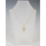 STUART GELNER, A 9 carat yellow gold cross pendant, set with six oval faceted peridot, on 9 carat