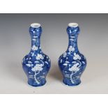 A pair of Chinese porcelain blue and white garlic neck bottle vases, late Qing Dynasty bearing