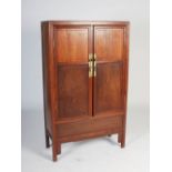 A Chinese dark wood food cupboard, the rectangular top above two panelled cupboard doors, opening to