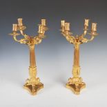 A pair of 19th century gilt bronze four light candelabra, the urn shaped nozzles supported on scroll