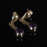 PRISM DESIGN, A pair of 9 carat yellow gold and amethyst cabochon pear-shaped drop earrings,