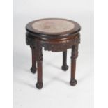 A Chinese dark wood urn stand, Qing Dynasty, the circular top with mottled red and white marble
