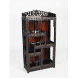 A Chinese dark wood display cabinet, late Qing Dynasty, the rectangular panelled top with a