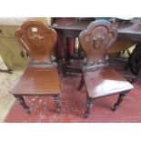 Pair of carved mahogany hall chairs