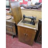 Singer sewing machine in oak cabinet