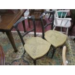 Pair of ebonised and hessian seated dining chairs