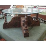 Heavily carved Oriental glass top coffee table - D: 91cm