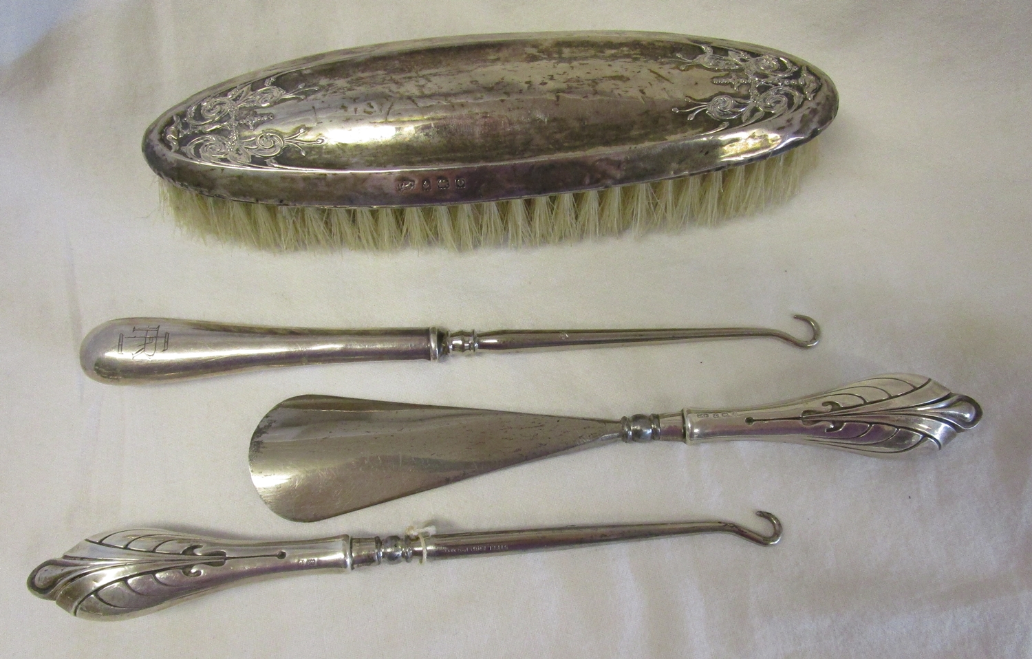 Collection of white metal to include hallmarked silver brush, button hooks etc