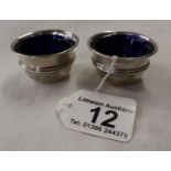 Pair of silver condiment pots with blue glass liners