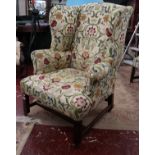 Upholstered wing-back armchair on casters