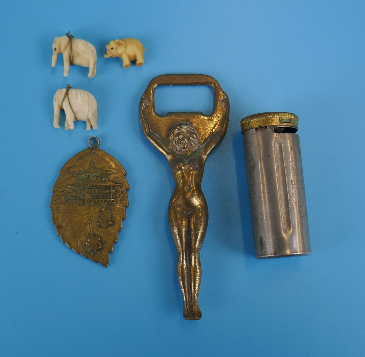 Collectables to include saucy bottle opener and Japanese locket with inscription verso