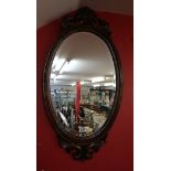 Oval bevelled glass mirror with carved wood frame