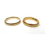 A 22ct gold wedding band together with a