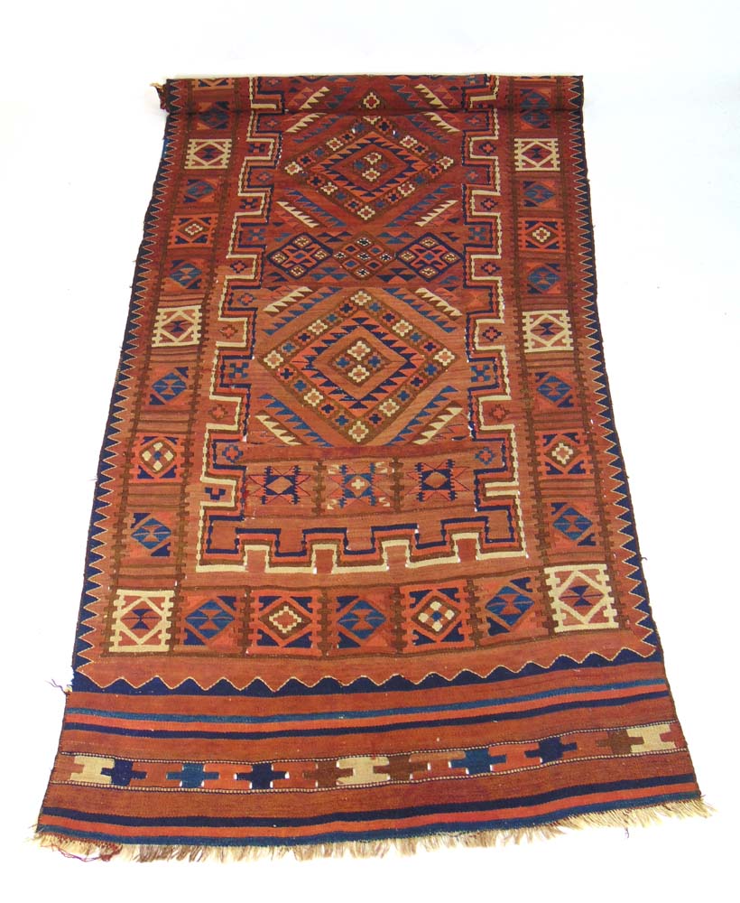 A handwoven Persian kilim, the red groun