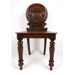 A 19th century oak hall chair, the circu