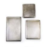 Three silver cigarette cases having engi