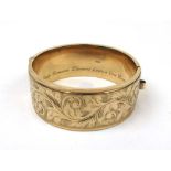A 9ct gold bangle having engraved scroll