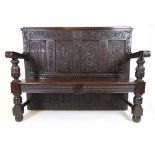 A Victorian carved oak settle made from