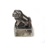 A white metal Foo dog scroll weight. App