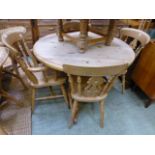 A waxed pine circular pedestal table wit