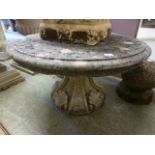 A weathered stoneware circular table on