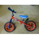 A child's red balance bike