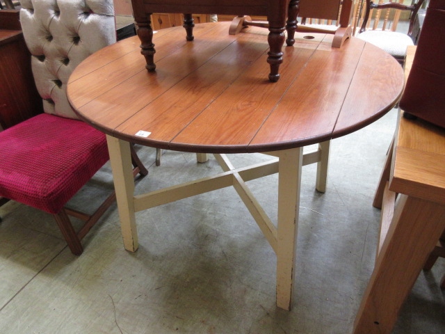 A circular pine topped table with a crea