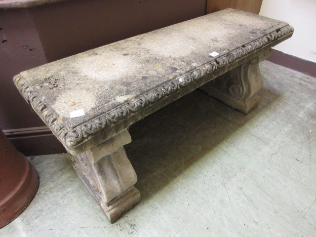 A weathered stoneware garden bench