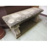 A weathered stoneware garden bench