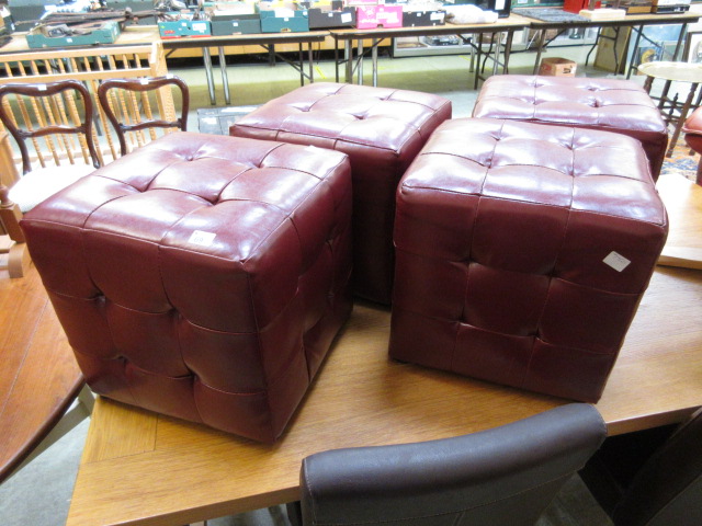 Four red leatherette upholstered stools