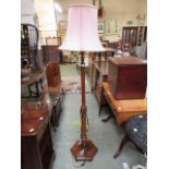 A 1930's walnut standard lamp with pink