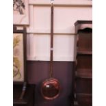 A brass and copper bed warming pan