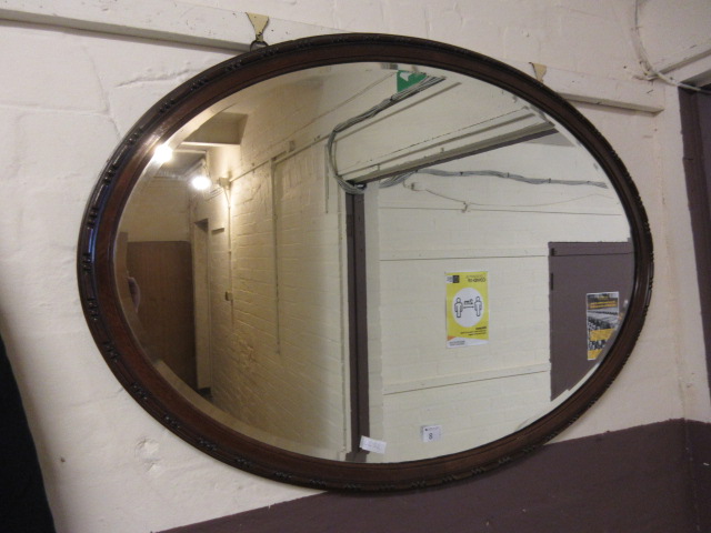 A walnut framed bevel glass wall mirror