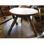A three-legged circular wooden stool