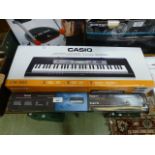 A boxed Casio keyboard together with stand