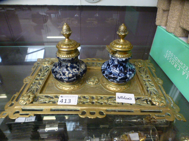 A brass embossed inkstand with two ceram