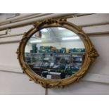 An ornate gilt framed oval mirror