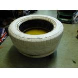 A white painted tyre planter on castors