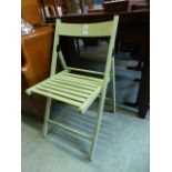 A lime green painted folding chair