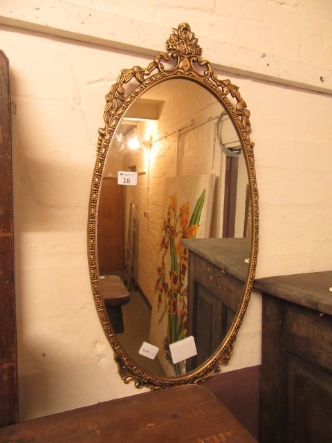 A gilt metal framed oval wall mirror