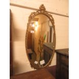 A gilt metal framed oval wall mirror