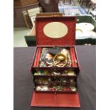 A red leatherette jewellery box containi