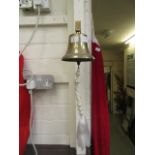 A reproduction wall mounted brass bell