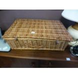 A wicker picnic basket with contents
